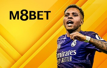 M8BET promotional banner featuring a football player in a Real Madrid jersey celebrating passionately, set against a bright yellow geometric background with the M8BET logo.